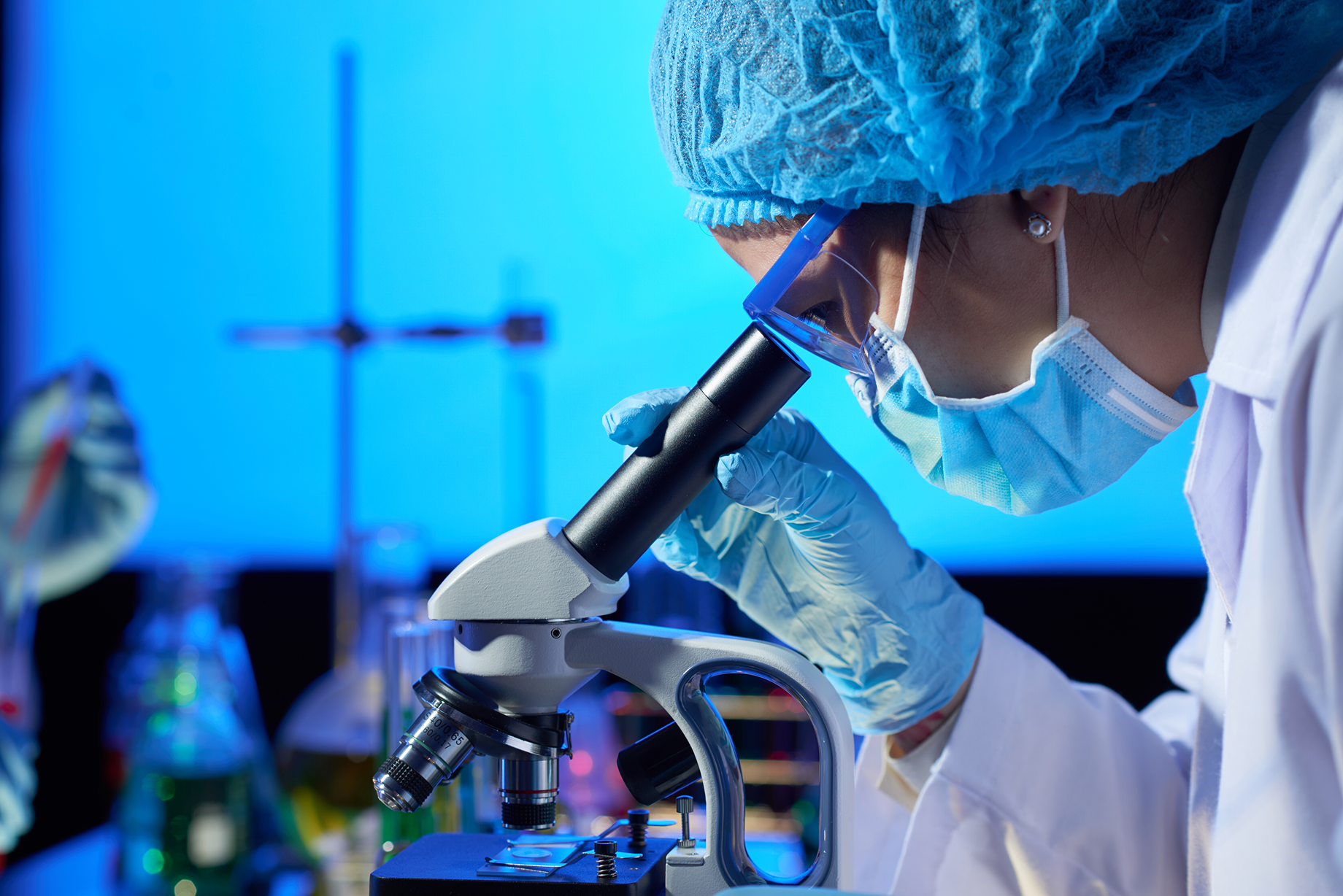 Researcher examining samples under a microscope