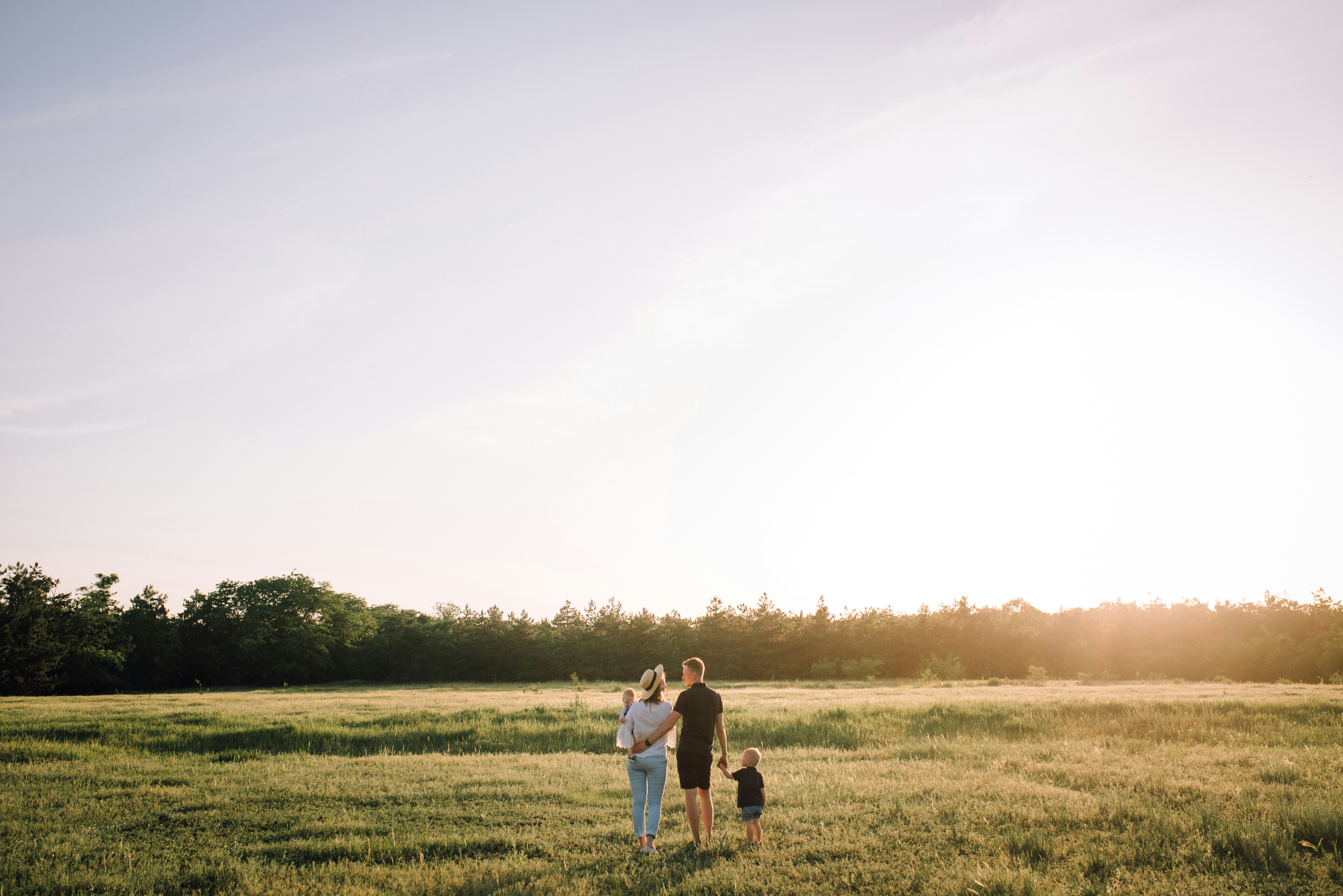 A family together in a field at sunset